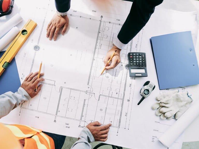 Real estate planners analyze a blueprint sheet